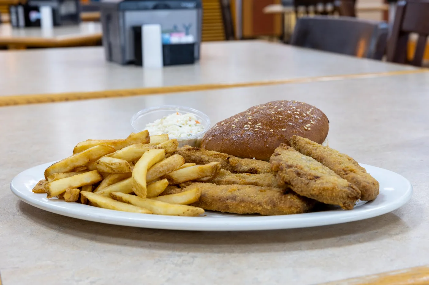 Golden fried fish and chicken tenders plate with fries and coleslaw