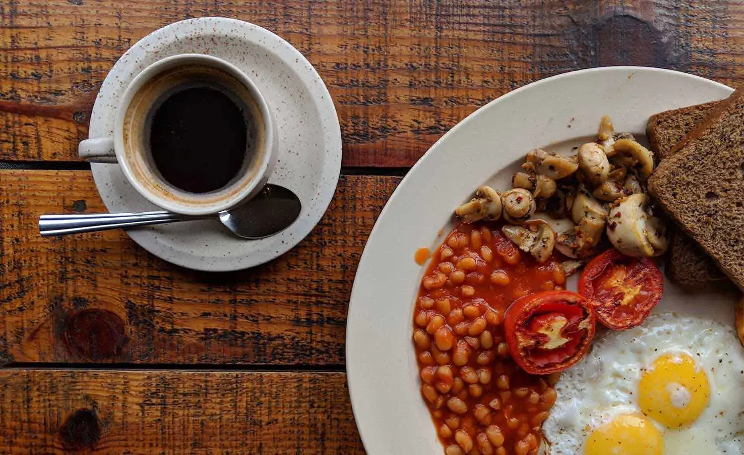 Breakfast plate with eggs, baked beans, tomato and toast